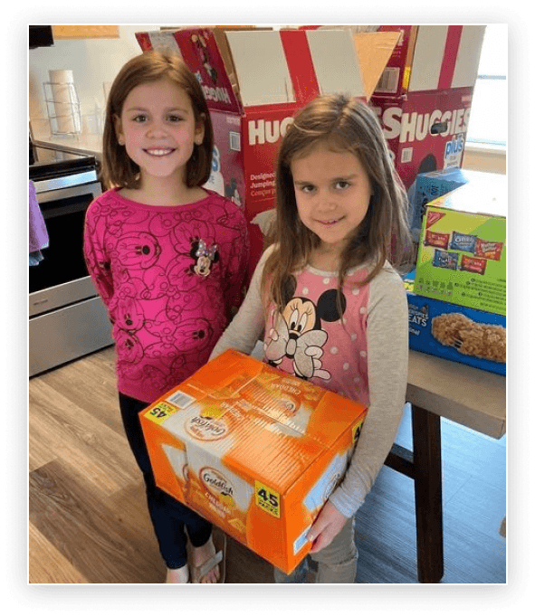 Two children holding a box of food